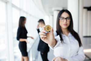 blockchain investment concept business woman leader holding bitcoin front discussing team office Blog